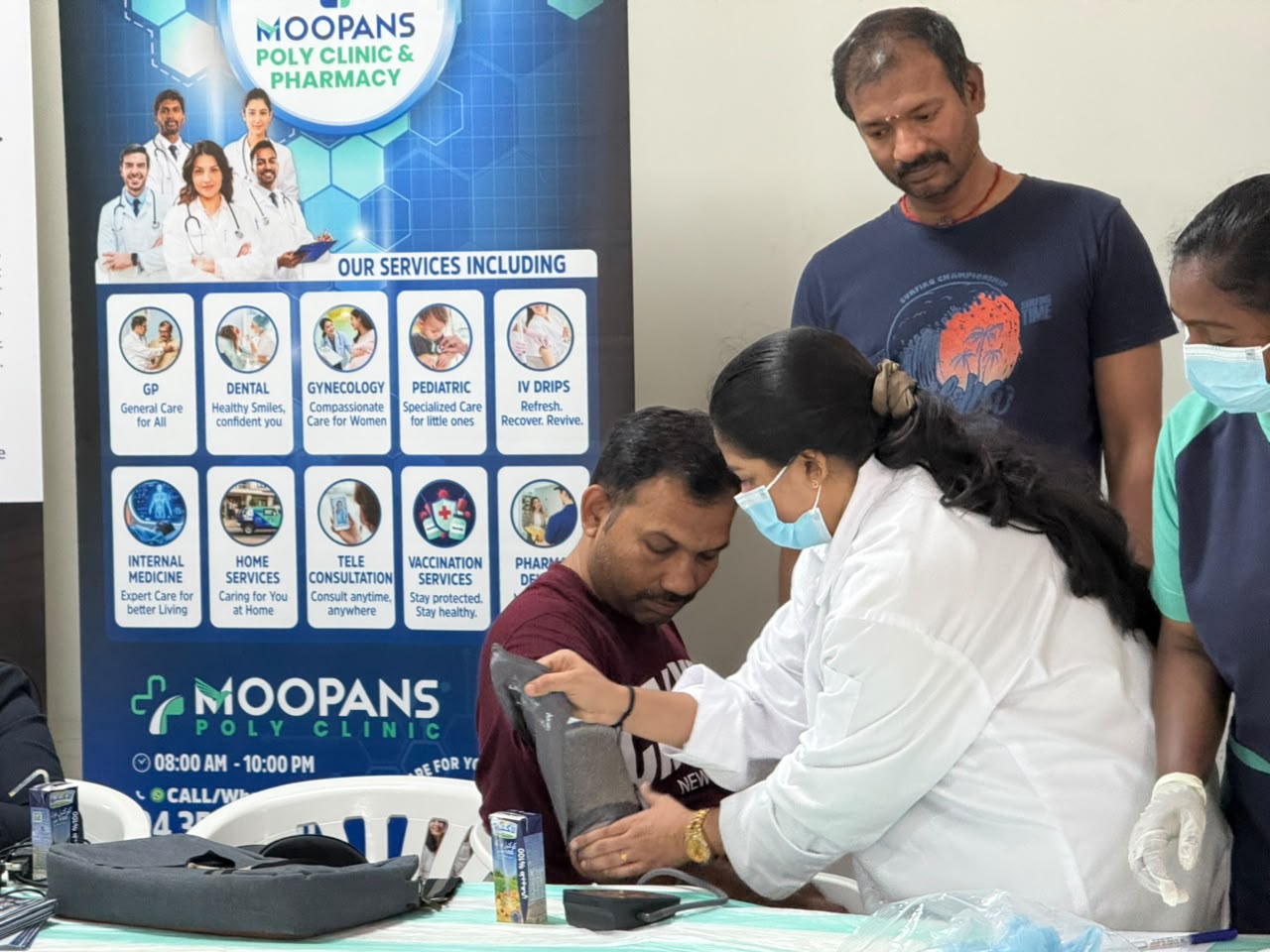 Healthcare professional checking an attendee’s blood pressure at a Moopans medical camp